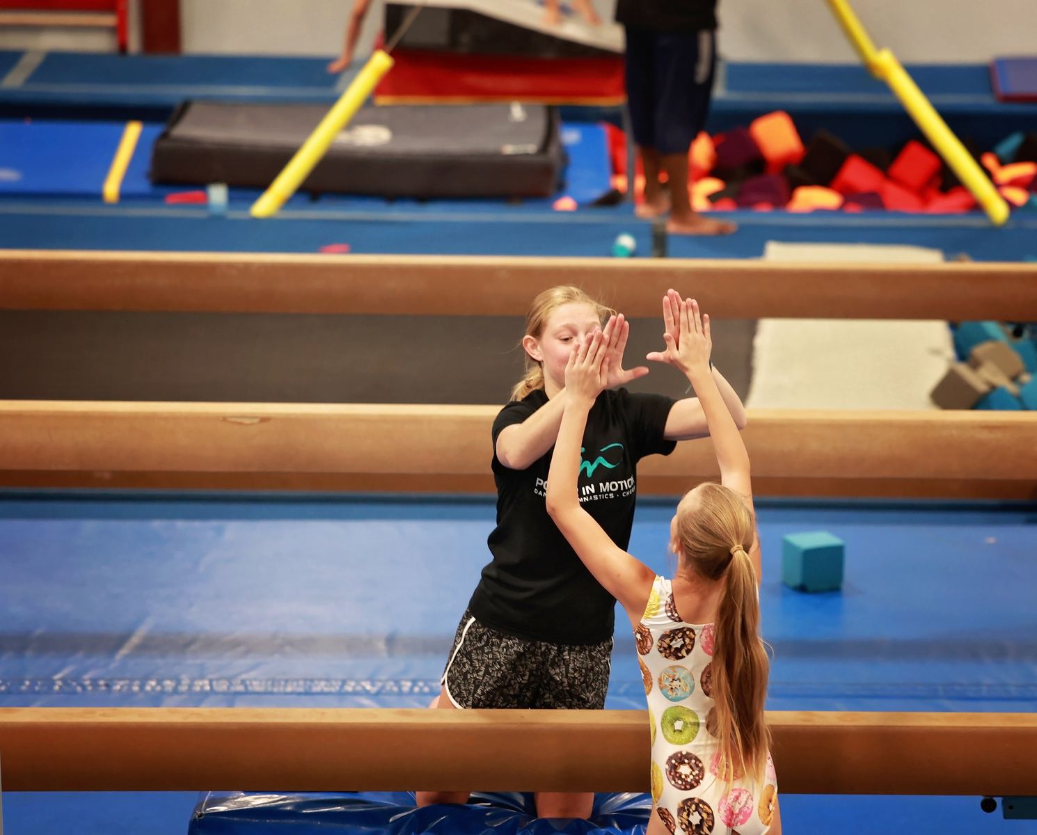 Coach helping a young gymnast on the beam